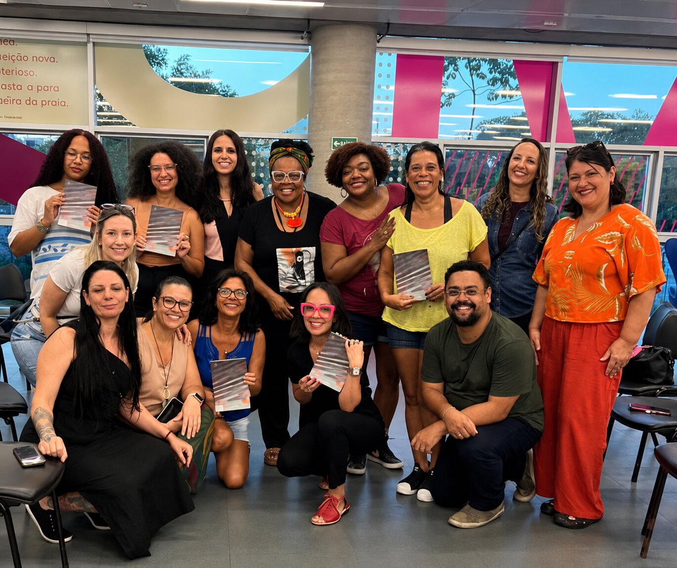 Outro encontro do clube de leitura, grupo maior posando com o livro do mês